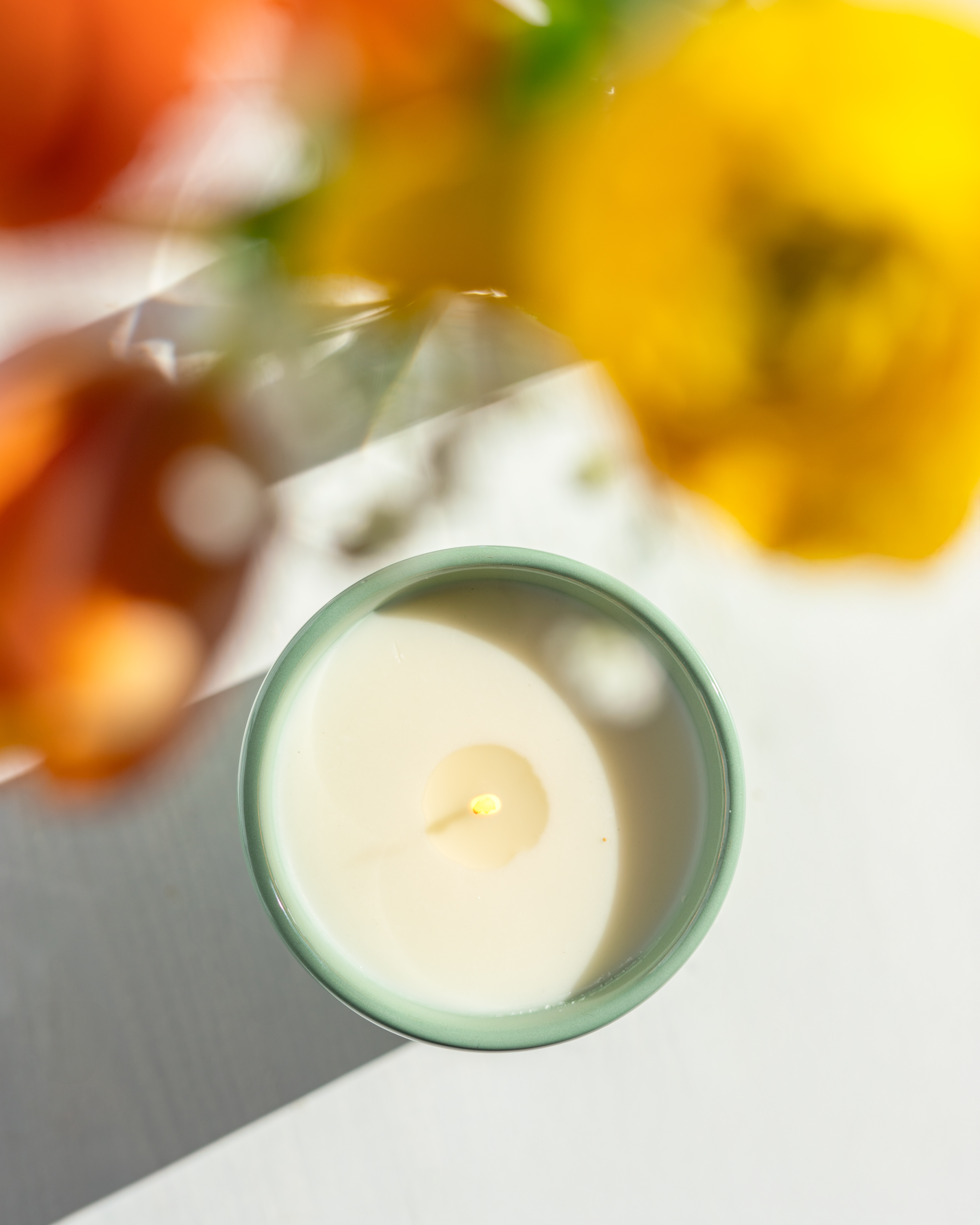 Kerze in Vogelperspektive neben einem Blumenstrauß