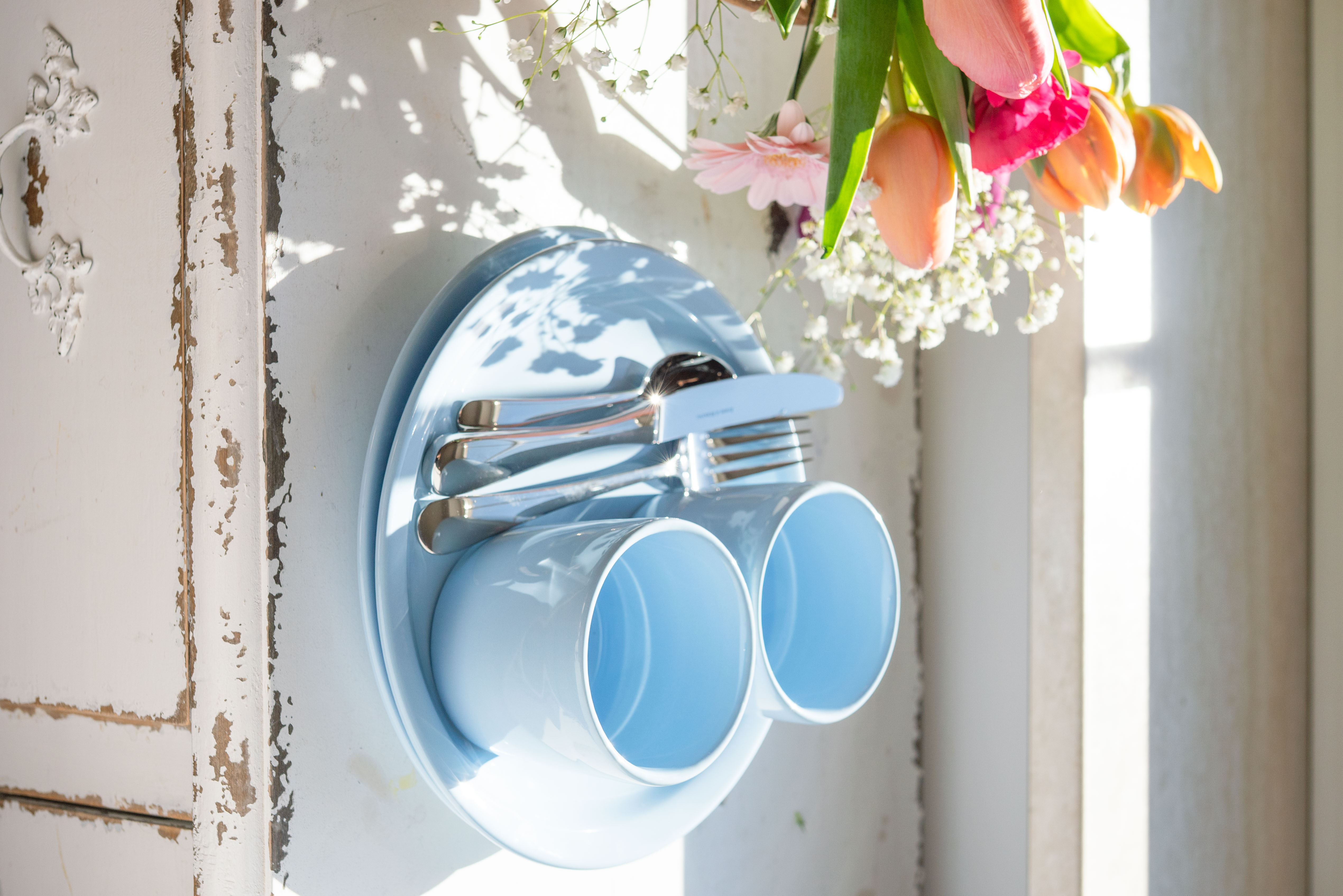 Blauer Teller und Becher auf einem Schrank