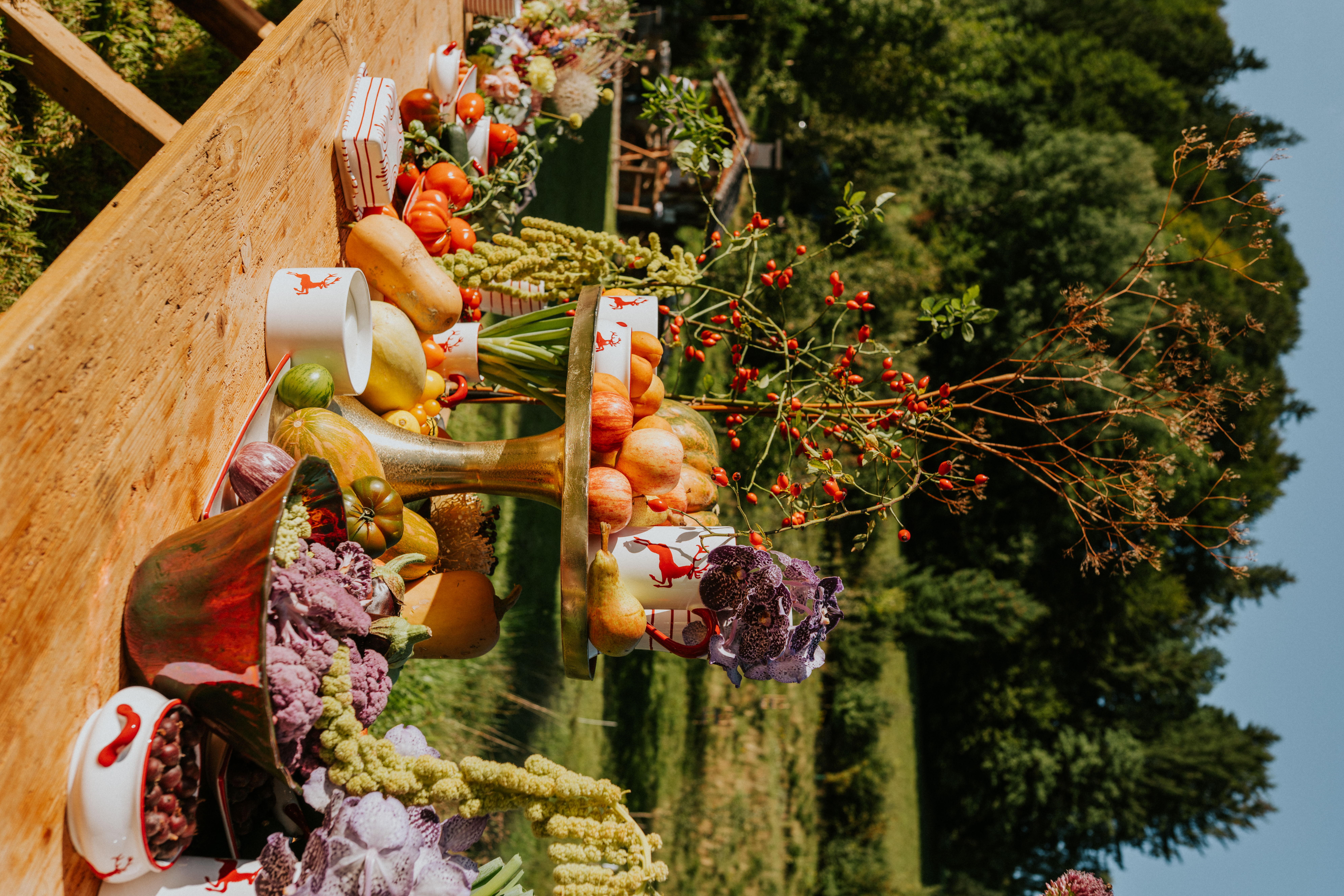 Gedeckter Herbsttisch im freien mit Kürbissen und Gmundner Keramik Geschirr im Design Rubinroter Hirsch
