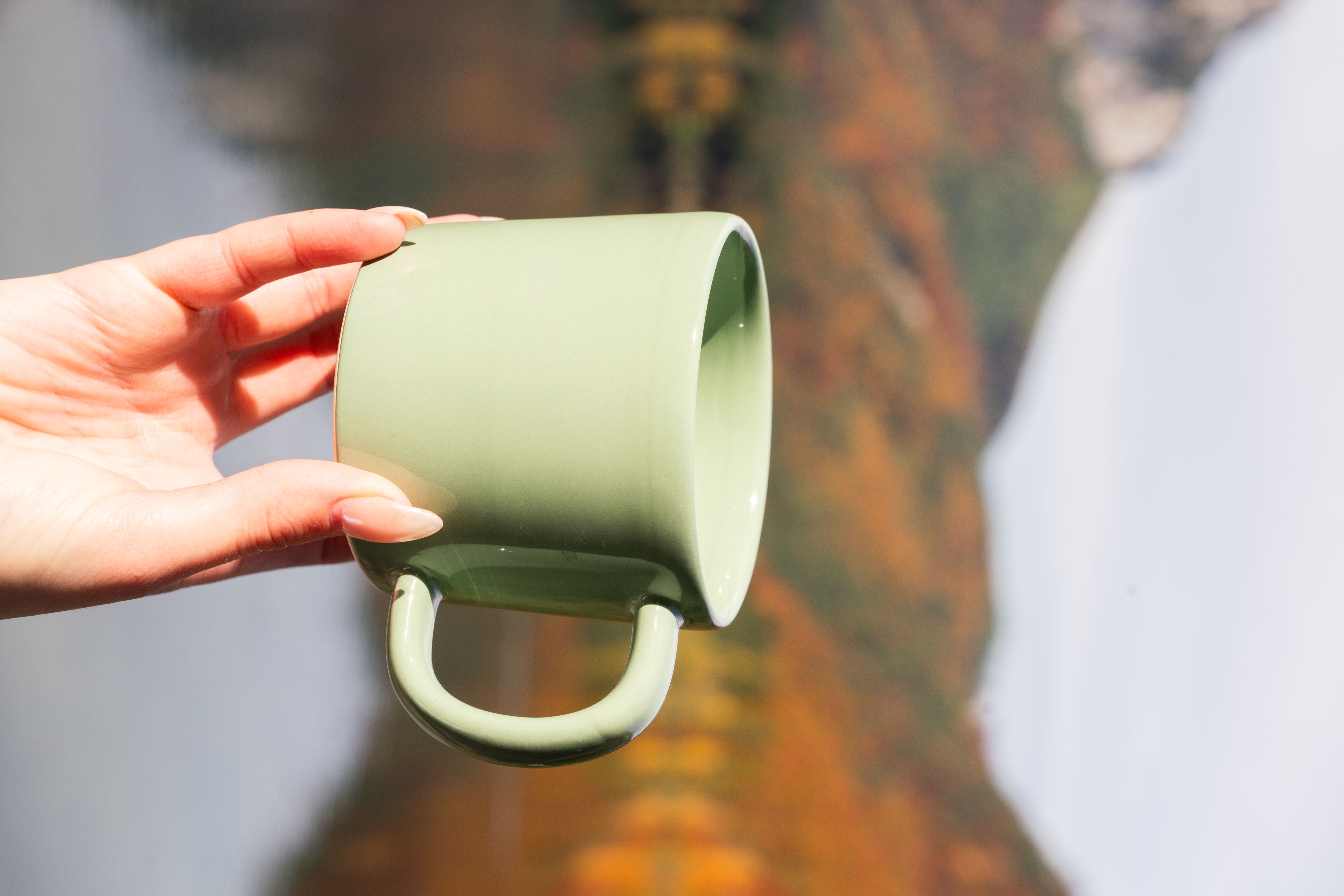 Salbeigrüne Tasse wird in einer Hand gehalten