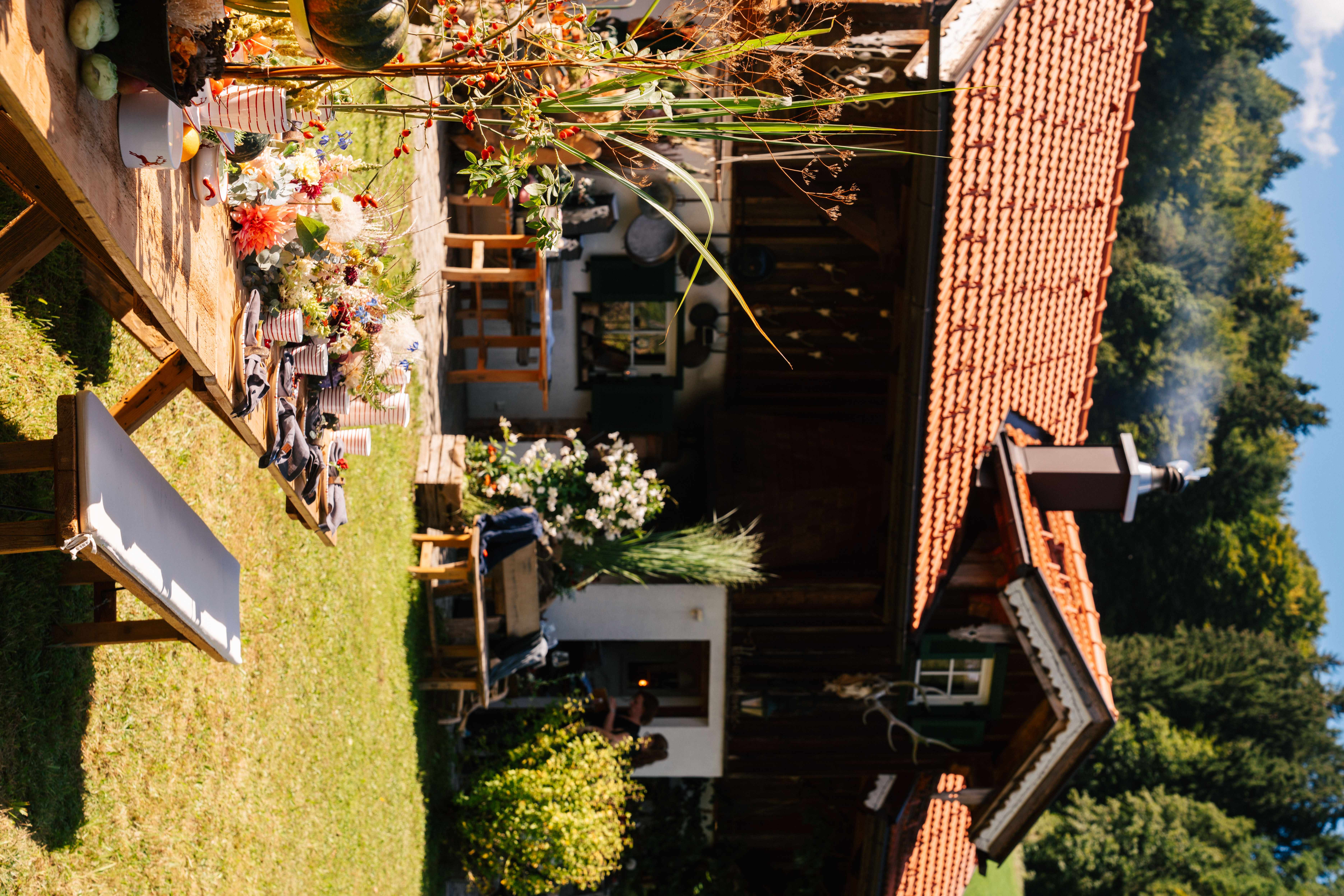 Ein gedeckter Tisch auf einer Wiese vor einem alten Haus