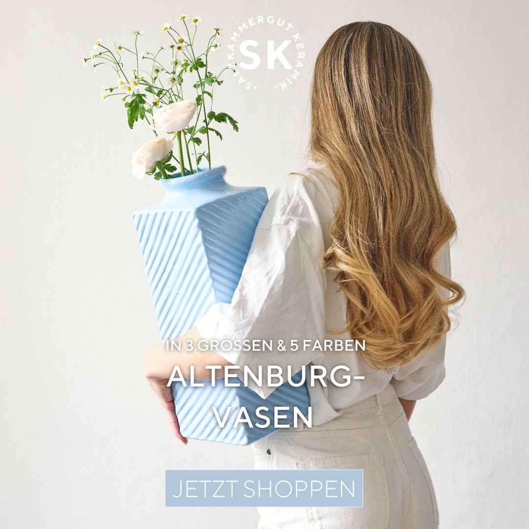 Eine Frau hält eine Vase mit Blumen in der Hand. Altenburg Vasen jetzt shoppen
