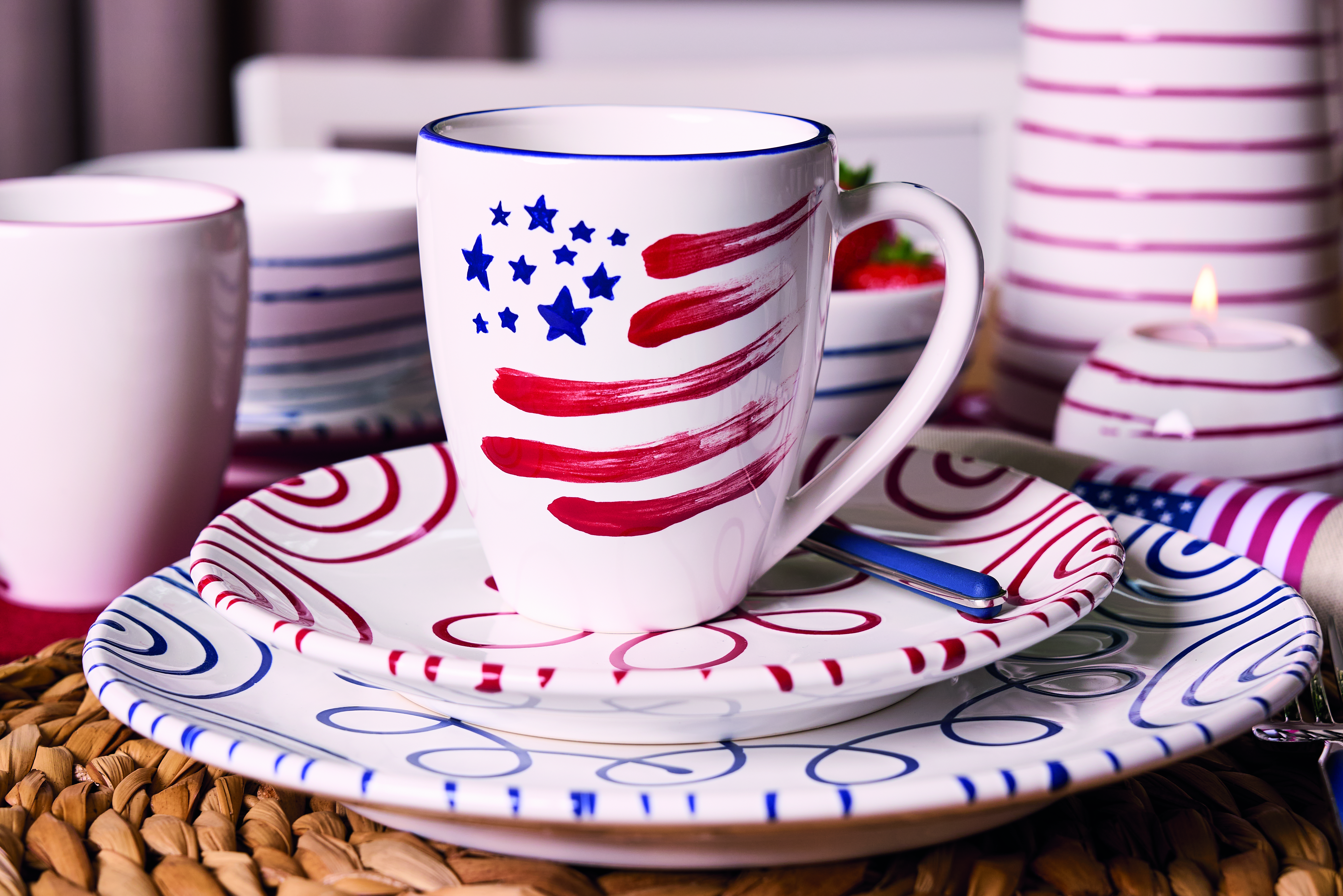Eine Tasse mit gemalter USA Flagge auf Rot- und Dunkelblaugeflammten Teller