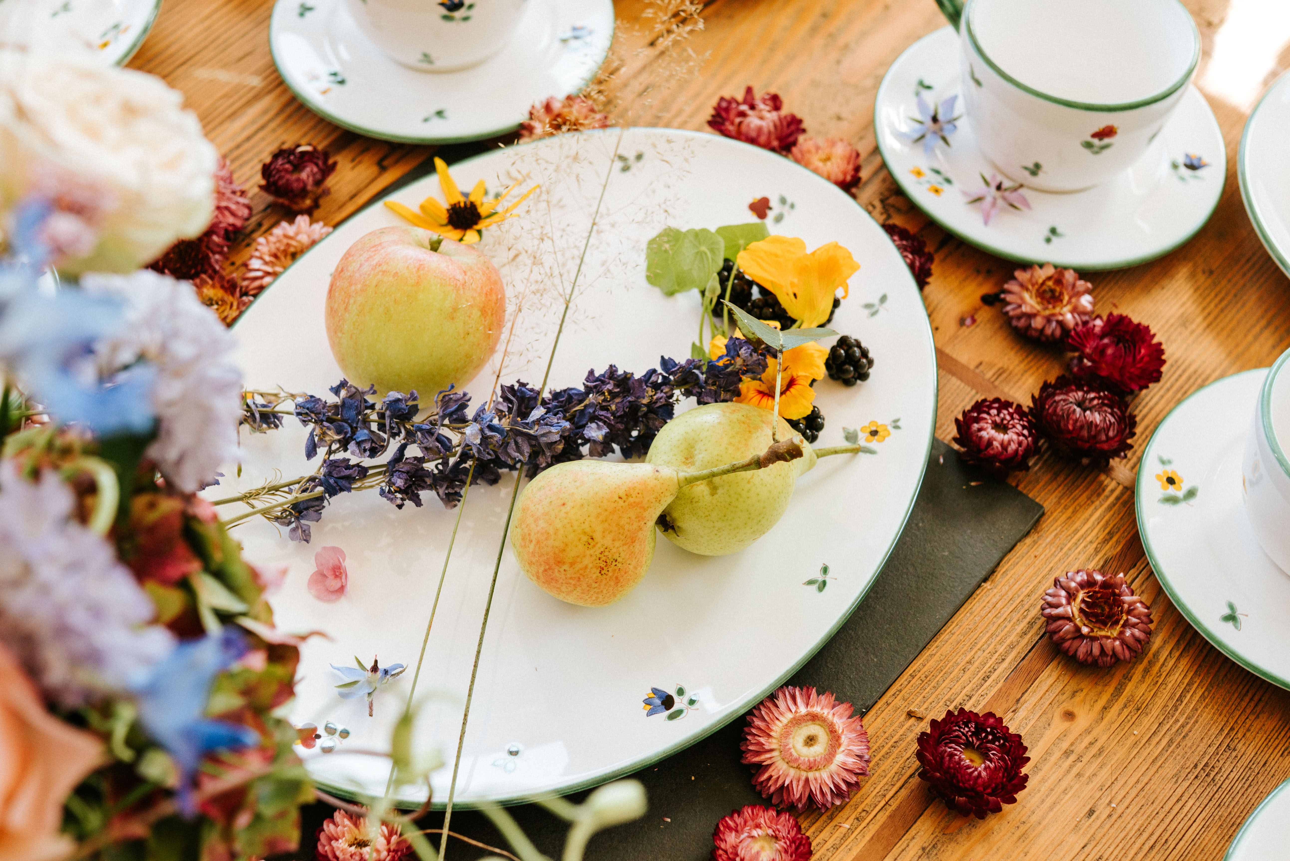 Platte im Design Streublume auf einem Holztisch mit Trockenblumen