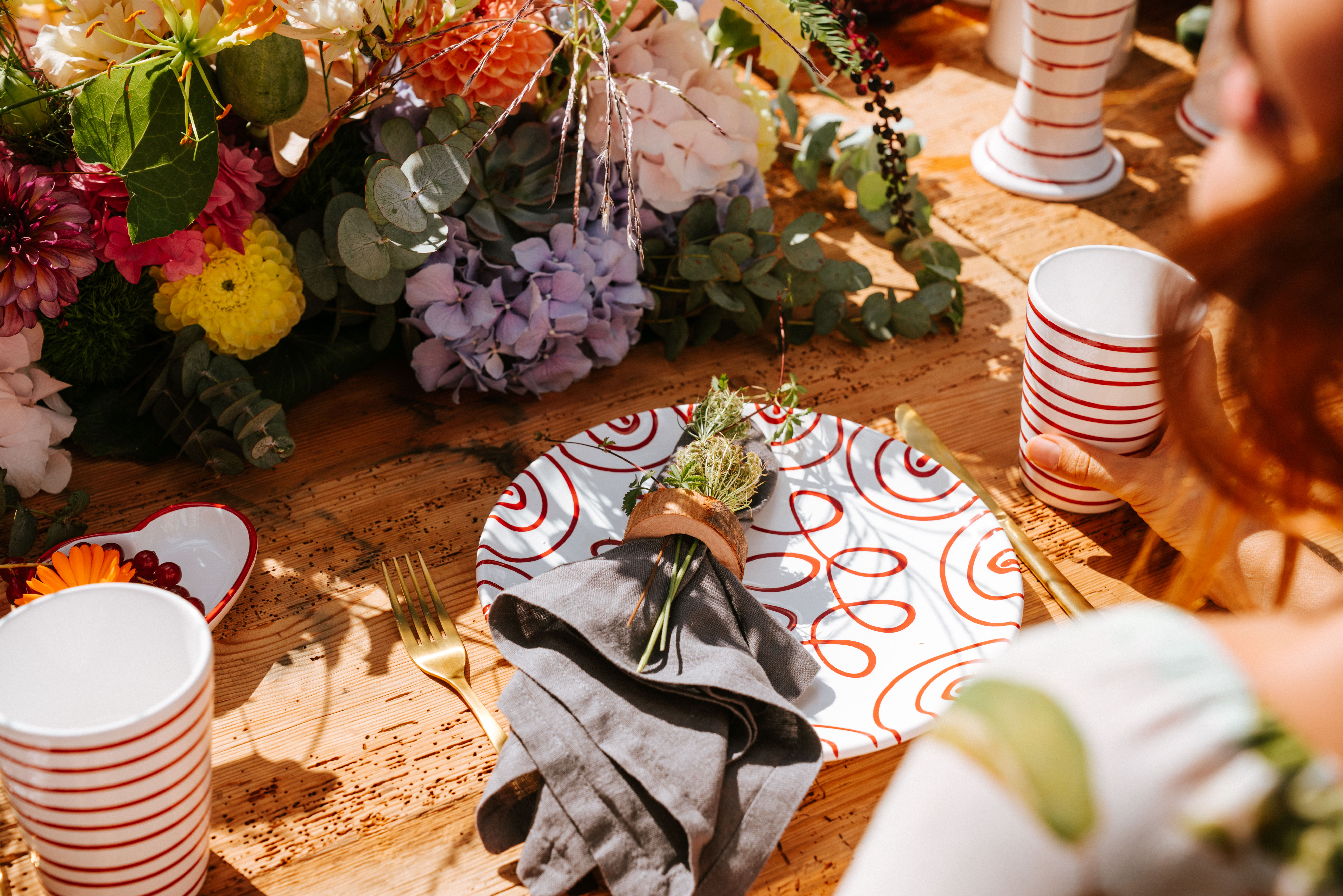 Herbstlich gedeckter Tisch mit Teller und Becher im Design Rotgeflammt