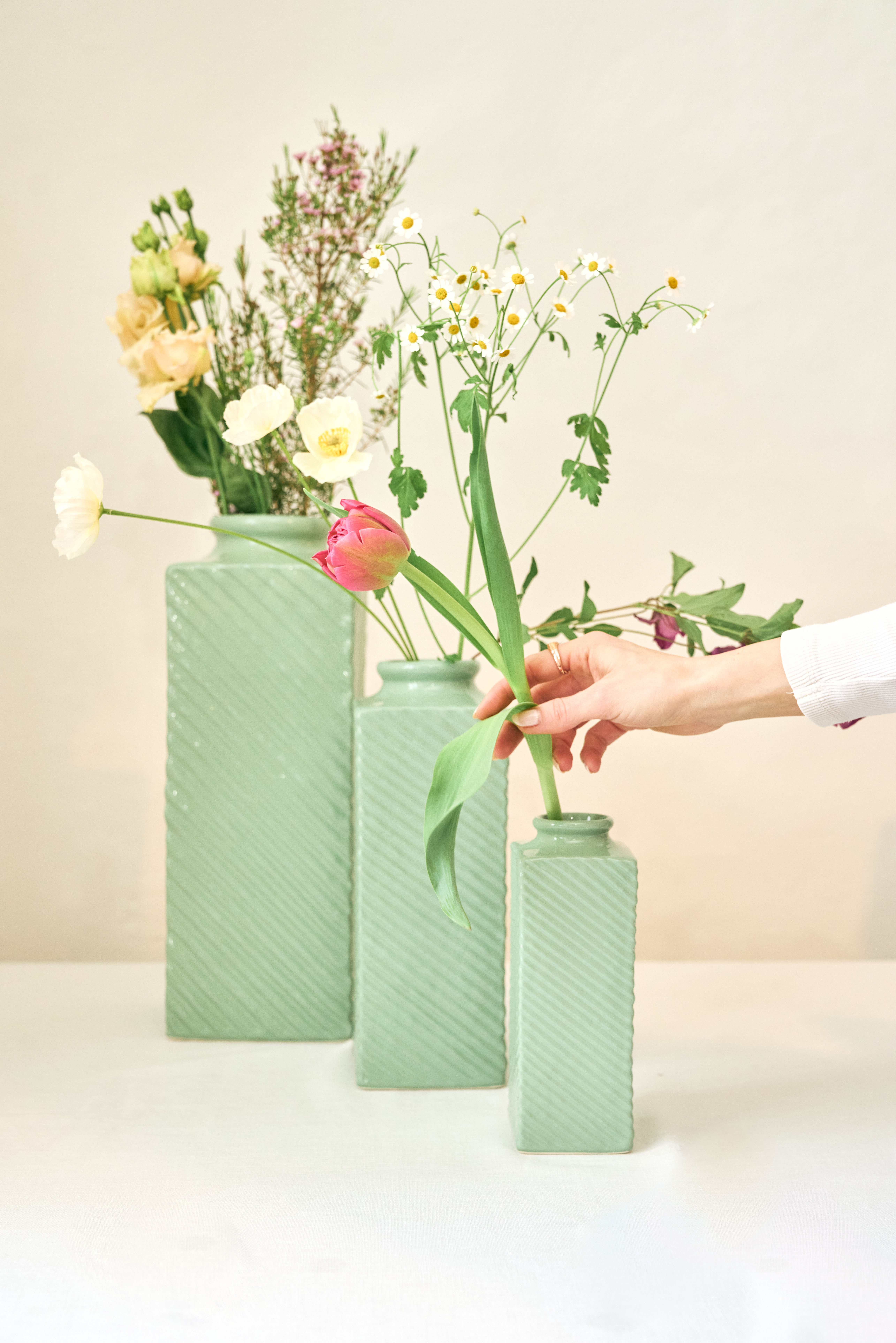 Drei Grüne Vasen in verschiedenen Größen mit verschiedenen Frühlingsblumen