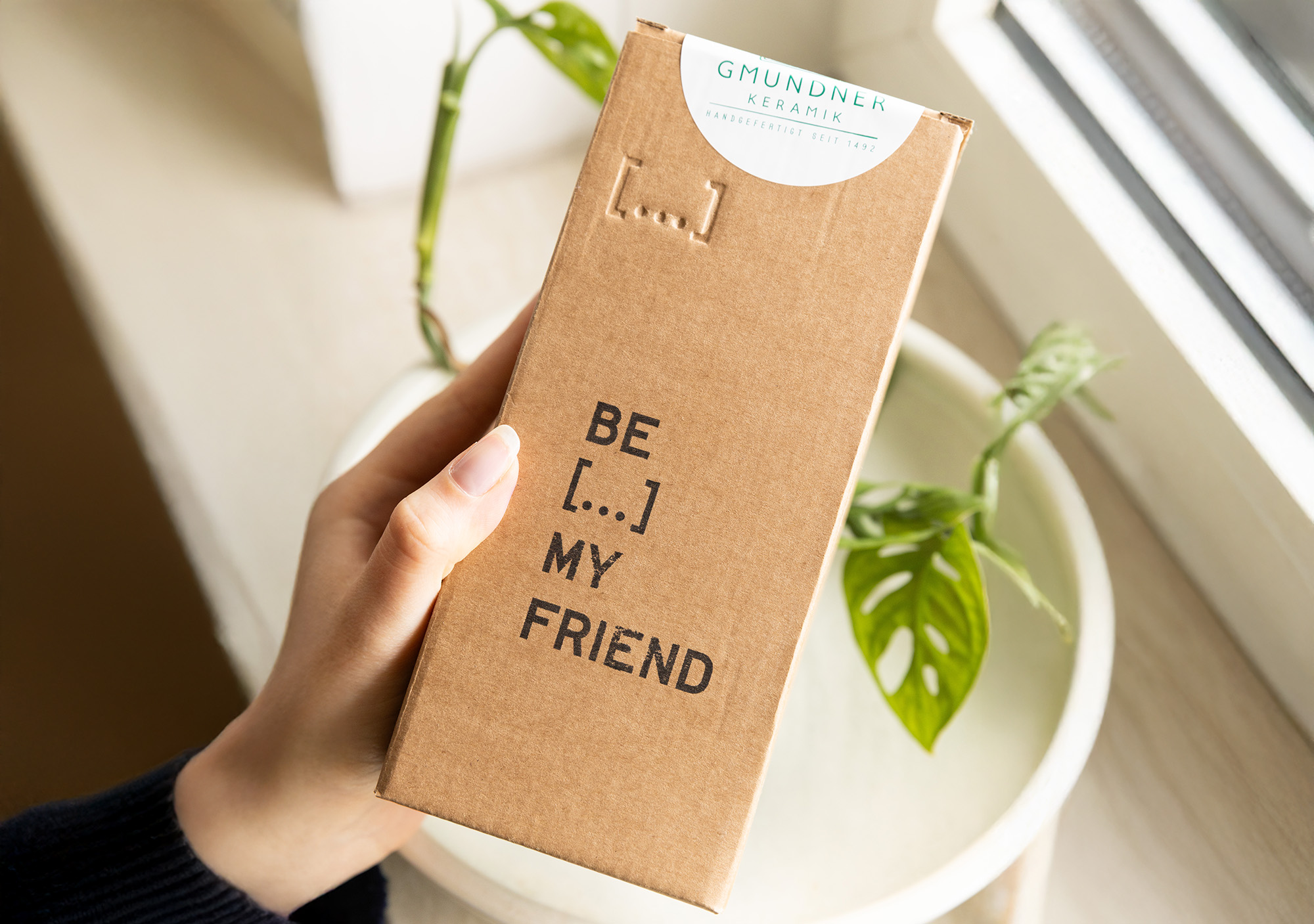 braune Verpackung mit der Aufschrift "Be...my friend" wird in einer Hand gehalten
