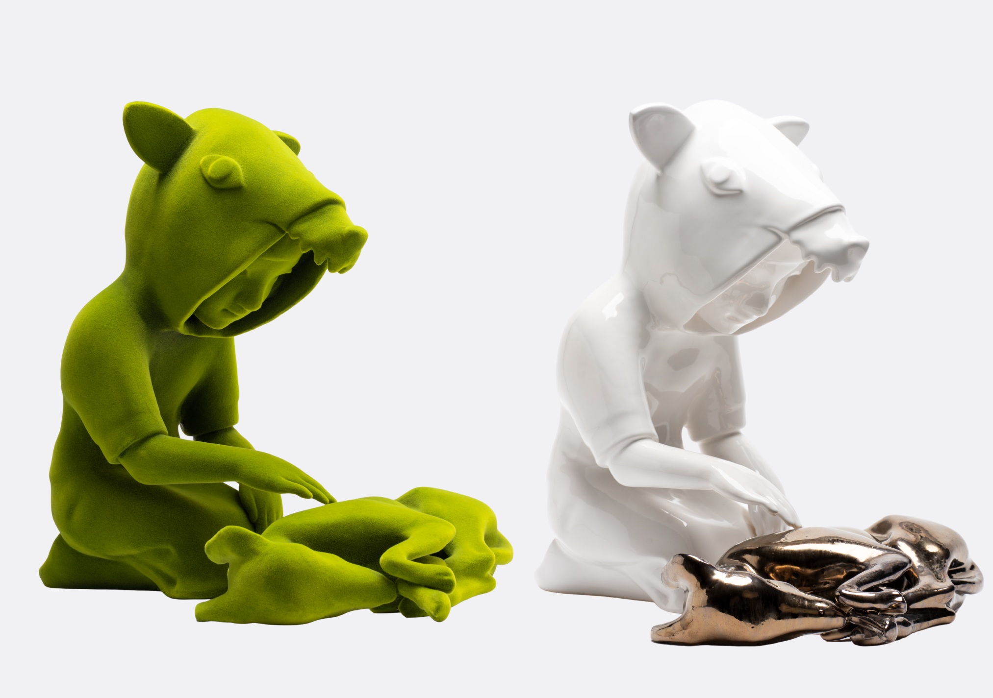 Zwei Keramikfiguren in grün und weiß die am Boden knien und einen Hund aus Keramik streicheln